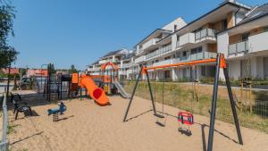 a playground in front of a apartment building at Apartamenty Sun & Snow Baltic Garden in Sztutowo