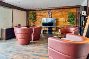 a lobby with leather chairs and a flat screen tv at ARTHOTEL Haar in Haar