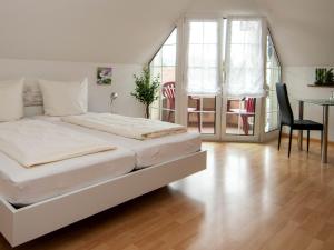 a bedroom with a white bed and a table and chairs at Hotel Scheffelhof in Bad Säckingen