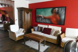 ein Wohnzimmer mit einem Sofa, Stühlen und einem Gemälde in der Unterkunft Herrschaftliches Apartment in historischer Villa in Hanau am Main