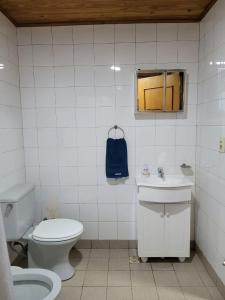 bagno con servizi igienici, lavandino e borsa blu di Iguazu House a Puerto Iguazú