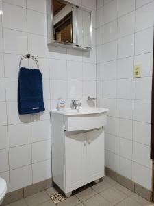 bagno bianco con lavandino e specchio di Iguazu House a Puerto Iguazú
