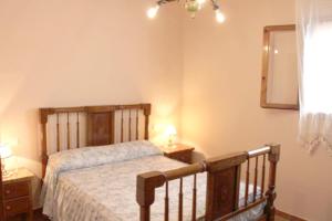 テウラーダにあるFinca Vicente - charming, Finca style holiday villa in Teuladaのベッドルーム(木製ベッド1台、鏡付)