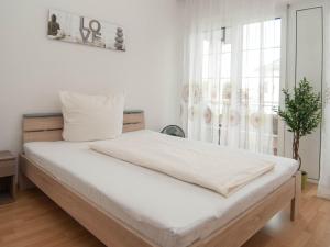 Schlafzimmer mit einem Bett mit weißer Bettwäsche und einem Fenster in der Unterkunft Hotel Scheffelhof in Bad Säckingen
