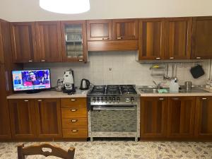 a kitchen with wooden cabinets and a stove top oven at Nonna Maria Rosa in Senise
