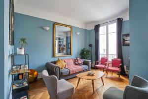 a living room with a couch and chairs and a mirror at Apartment place de l'Etoile By Studio prestige in Paris