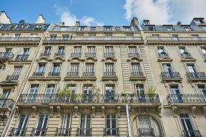 a large building with balconies on the side of it at Apartment place de l'Etoile By Studio prestige in Paris