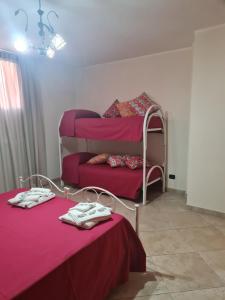 San Pietro in LamaにあるB&B Il Principeの赤いシーツが備わるドミトリールームの二段ベッド2台分です。
