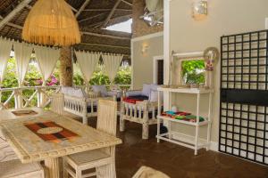 a room with a table and chairs and a mirror at Bahari Ya Mawazo in Watamu