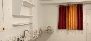a kitchen with a red curtain and a sink at Happy Homes , Thekkady in Vandiperiyār