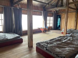 a room with two beds in a room with windows at MOONG Homestay & Coffee Tà Xùa in Bắc Yên