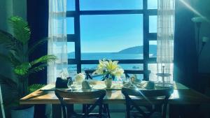 uma mesa de jantar com cadeiras e uma grande janela em Mango House3-LuxurySweet I Biggest unit I infinity pool I Wifi-JQ em Kota Kinabalu