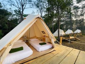 two beds in a bell tent on a wooden deck at Camping Park Resort in Kampong Speu