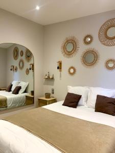 - une chambre avec 2 lits et des miroirs sur le mur dans l'établissement Domaine le Vaxergues, à Saint-Affrique