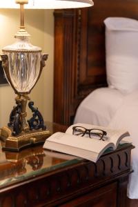 a lamp and a book on a glass table with a lamp gmaxwell gmaxwell at Powerscourt Hotel, Autograph Collection in Enniskerry