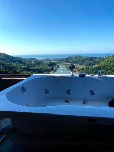 a bath tub with a view of the ocean at Habura'da Bungalow in Rize
