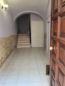 pasillo con suelo de baldosa blanca y puerta en La Rustica mini apartment en Ortona