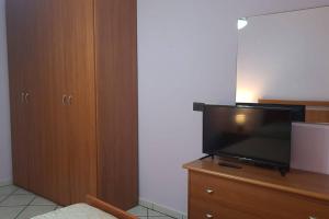 La Rustica mini apartment في أورتونا: يوجد تلفزيون بشاشة مسطحة فوق خزانة خشبية