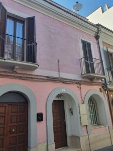 Edificio rosa con 2 puertas y balcón en La Rustica mini apartment en Ortona