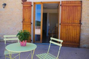 Domaine Joseph LAFARGE Wine Resort B&B في Lugny: طاولة و كرسيين وطاولة مع نبات