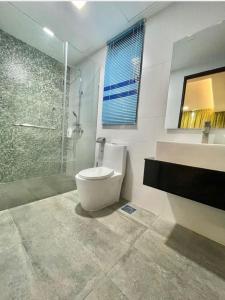 y baño con aseo, ducha y lavamanos. en VIVACITY SUITES , 2-8PAx 2CARD LEVEL 12, en Kuching