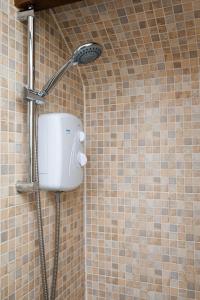 a shower in a bathroom with a shower head at Cosy Cottage in Historic Lincoln in Lincolnshire