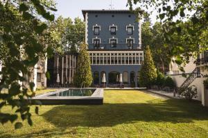 un gran edificio con un patio con una fuente en Balneario Font Vella- Adults Only, en Sant Hilari Sacalm