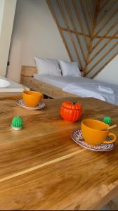 a wooden table with two cups and a pumpkin on it at Habura'da Bungalow in Rize