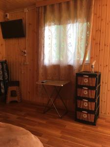 ein Schlafzimmer mit einem Tisch und einem Fenster mit einem TV in der Unterkunft Sunset Krikhi in Ambrolauri