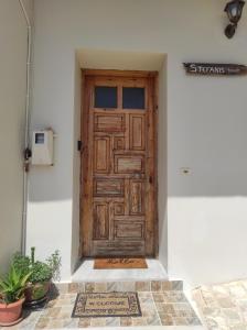 una puerta de madera en una pared blanca con una alfombra en Stefanis traditional house - Kampos, en Kámbos