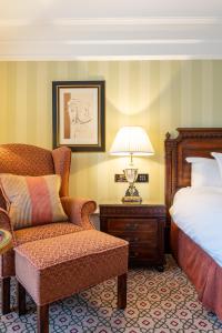 a bedroom with a bed and a chair and a lamp at Powerscourt Hotel, Autograph Collection in Enniskerry