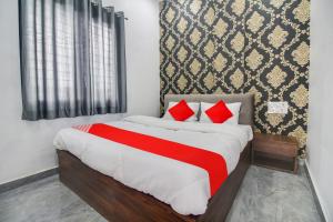 那格浦爾的住宿－OYO Flagship Hotel Ashoka Inn，一间卧室配有一张带红色枕头的大床