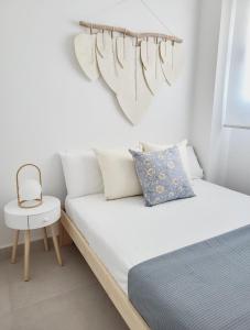 1 dormitorio blanco con 1 cama y 1 silla en ÁTICOS ROTA Punta Candor, en Rota