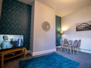 a living room with a tv and a table at Pass the Keys Cosy flat close to metro City and hospitals in Gosforth