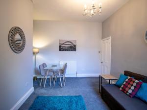 a living room with a couch and a table at Pass the Keys Cosy flat close to metro City and hospitals in Gosforth