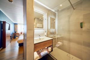uma casa de banho com um lavatório e um chuveiro em Arthotel Ana im Olympiapark em Munique
