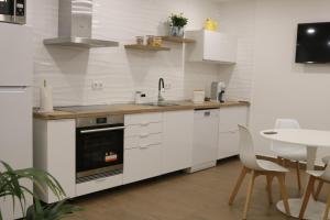 eine Küche mit weißen Schränken und einem Waschbecken und einem Tisch in der Unterkunft Casa dos Pexins Buzina Sitio in Nazaré