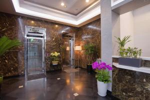 a lobby with a elevator and flowers on the wall at LEX Tourist Hotel in Seoul