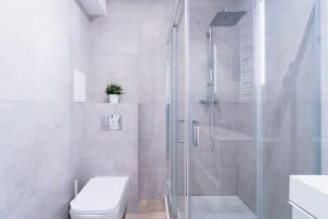 a white bathroom with a shower and a toilet at City Center - 3 Rooms - New Building - Private Parking Place - Garage in Wrocław