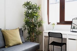a desk and chair in a room with a plant at City Center - 3 Rooms - New Building - Private Parking Place - Garage in Wrocław