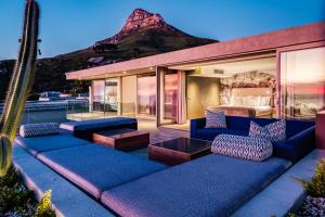 a patio with blue couches and a bed with a mountain at The Cheviots in Cape Town