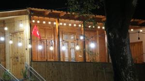 un edificio con luces y una bandera roja en él en Gigi, en Khvanchkara