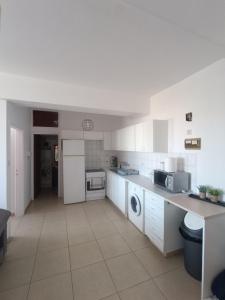 uma grande cozinha com armários e electrodomésticos brancos em Heart of the City em Limassol
