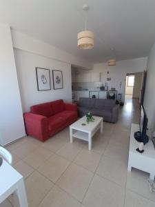 ein Wohnzimmer mit einem roten Sofa und einem Tisch in der Unterkunft Heart of the City in Limassol