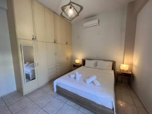 a bedroom with a white bed with two candles on it at Minimalist Flat with Balcony in Heraklio Town
