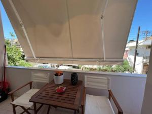 a table and chairs with a large umbrella on a balcony at Minimalist Flat with Balcony in Heraklio Town