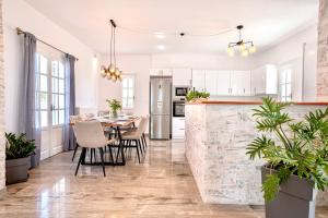 an open kitchen and dining room with a stone wall at Villa Nostos in Dhragoulás