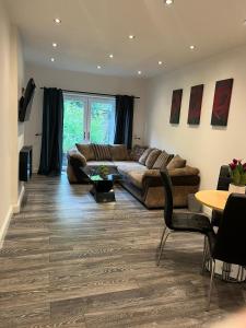 a living room with a couch and a table at Contemporary apartment Great Location with private car park in Keighley