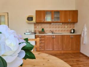 une cuisine avec des placards en bois et une fleur blanche sur une table dans l'établissement Úzkokolejky - apartmány Nová Bystřice, à Nová Bystřice