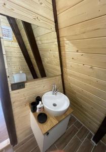 ein Badezimmer mit einem Waschbecken in einer Holzwand in der Unterkunft OLİVE GARDEN ANTALYA in Bahtılı
